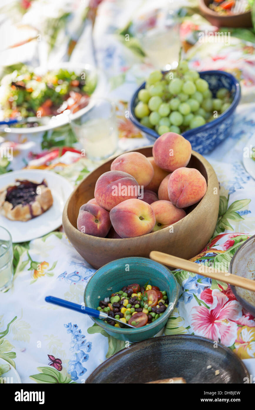 Un tavolo da giardino prevista con un buffet di insalate e verdure fresche e frutta. Foto Stock