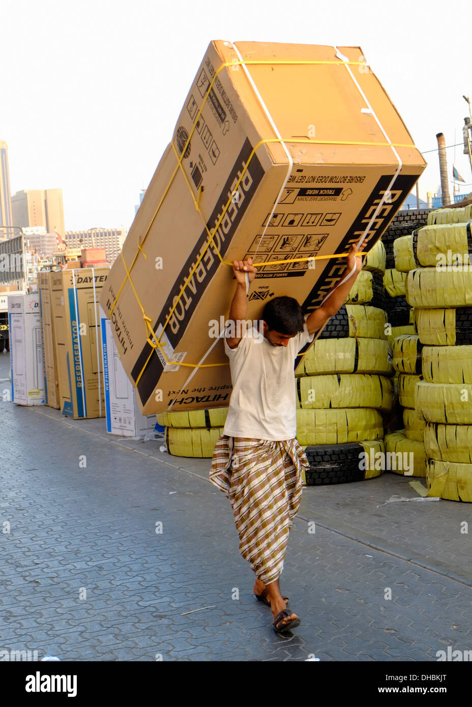 Uomo che porta cargo per il caricamento su un dhow presso il fiume Creek di Dubai Emirati Arabi Uniti EMIRATI ARABI UNITI Foto Stock