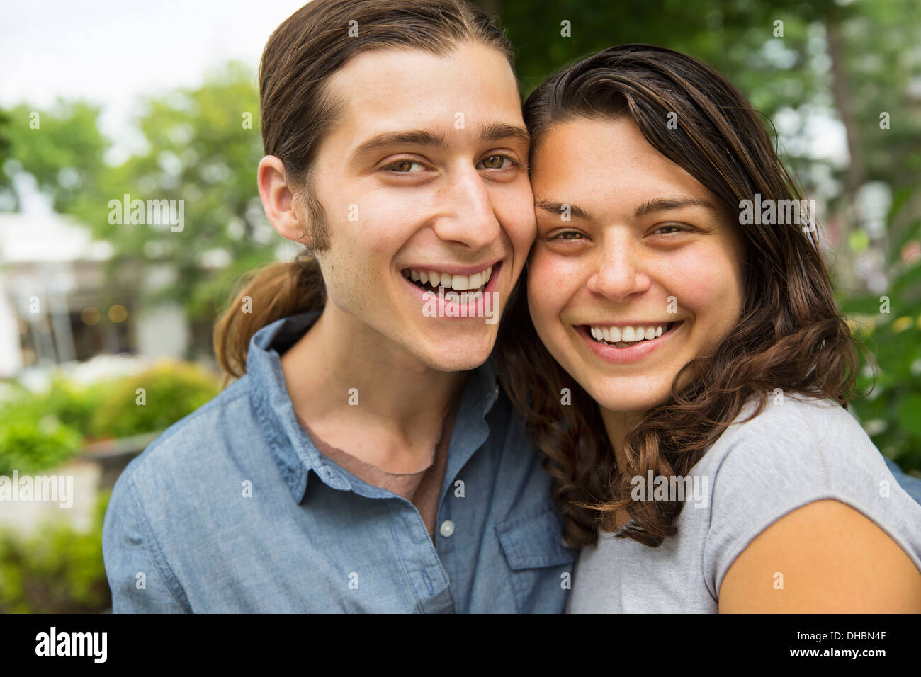 Una giovane coppia affiancati, flirtare e scattare fotografie. Foto Stock