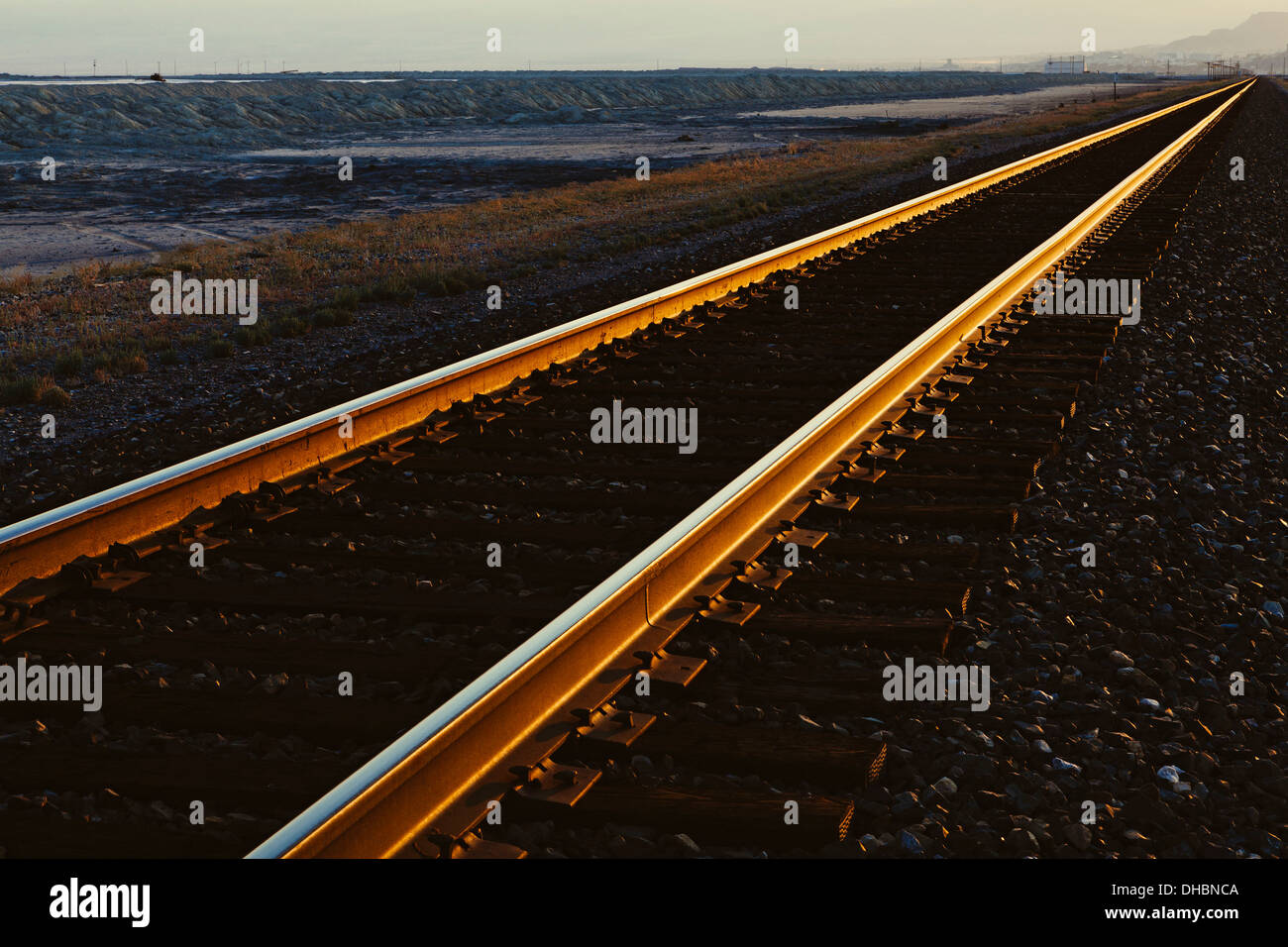 I binari della ferrovia che si estende attraverso il piatto Utah il paesaggio del deserto, al tramonto. Foto Stock