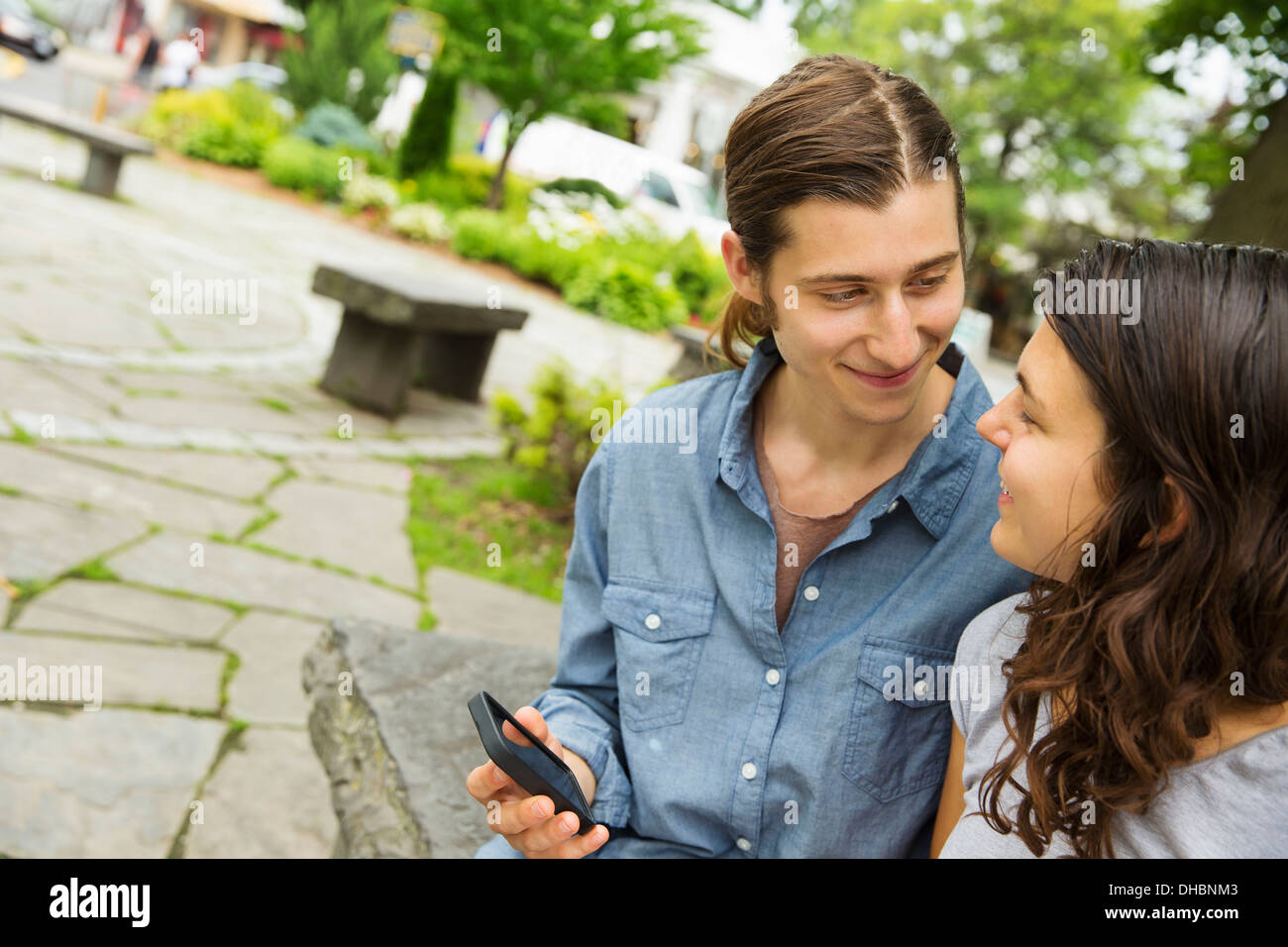 Una giovane coppia affiancati, flirtare e scattare fotografie. Foto Stock