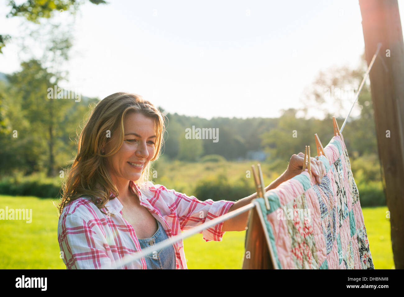 Una donna panni appesi sulla linea di lavaggio, nell'aria fresca. Foto Stock