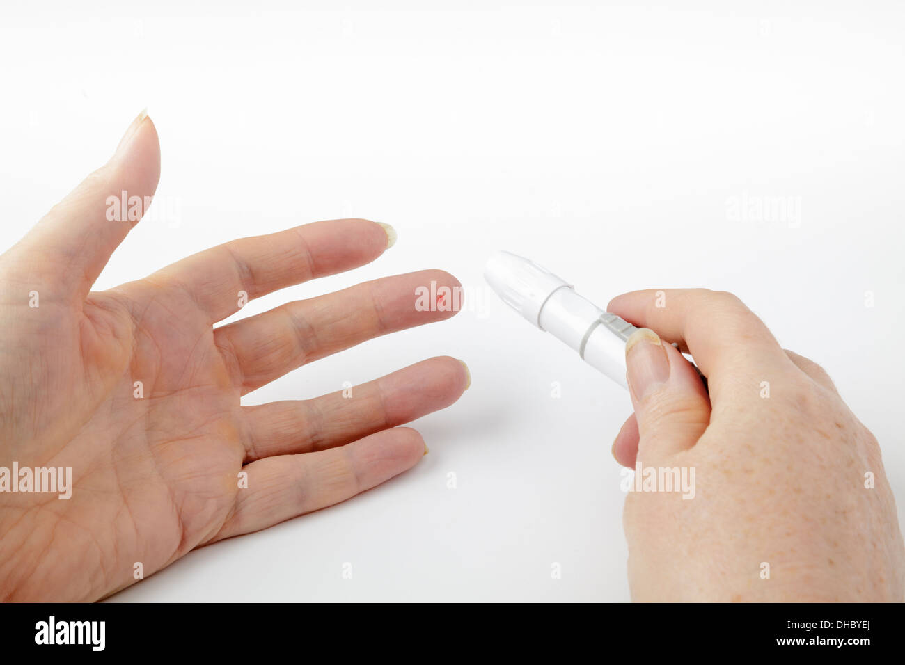 Pazienti diabetici il livello di glucosio nel sangue di prova, usando un bastone per perforare il dito Foto Stock