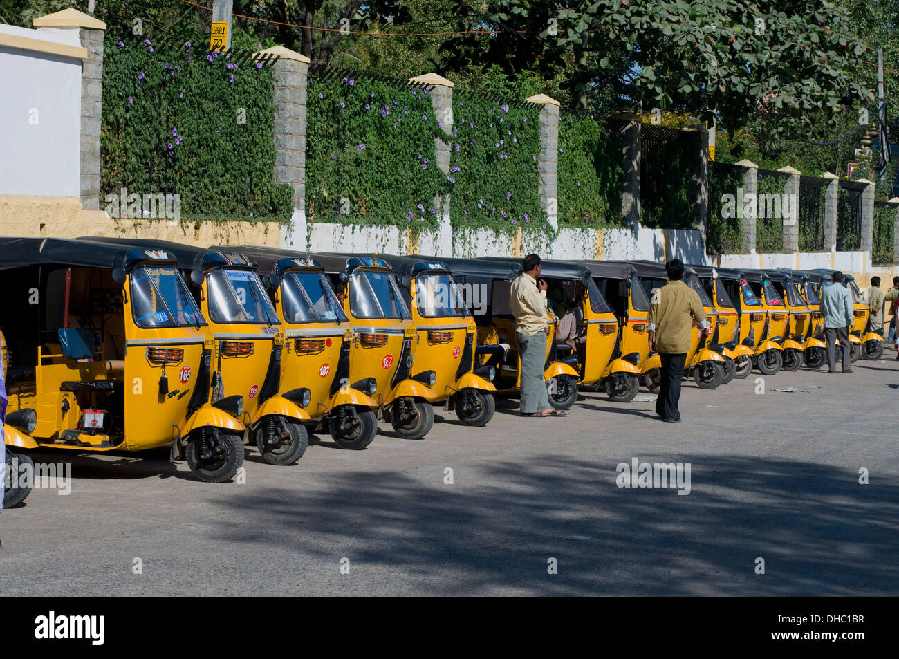 Rickshaws (tuk tuks) allineati al di fuori di Prashanti Nilayam, la dimora di pace del tardo Sri Sathya Sai Baba, in attesa di business. Foto Stock