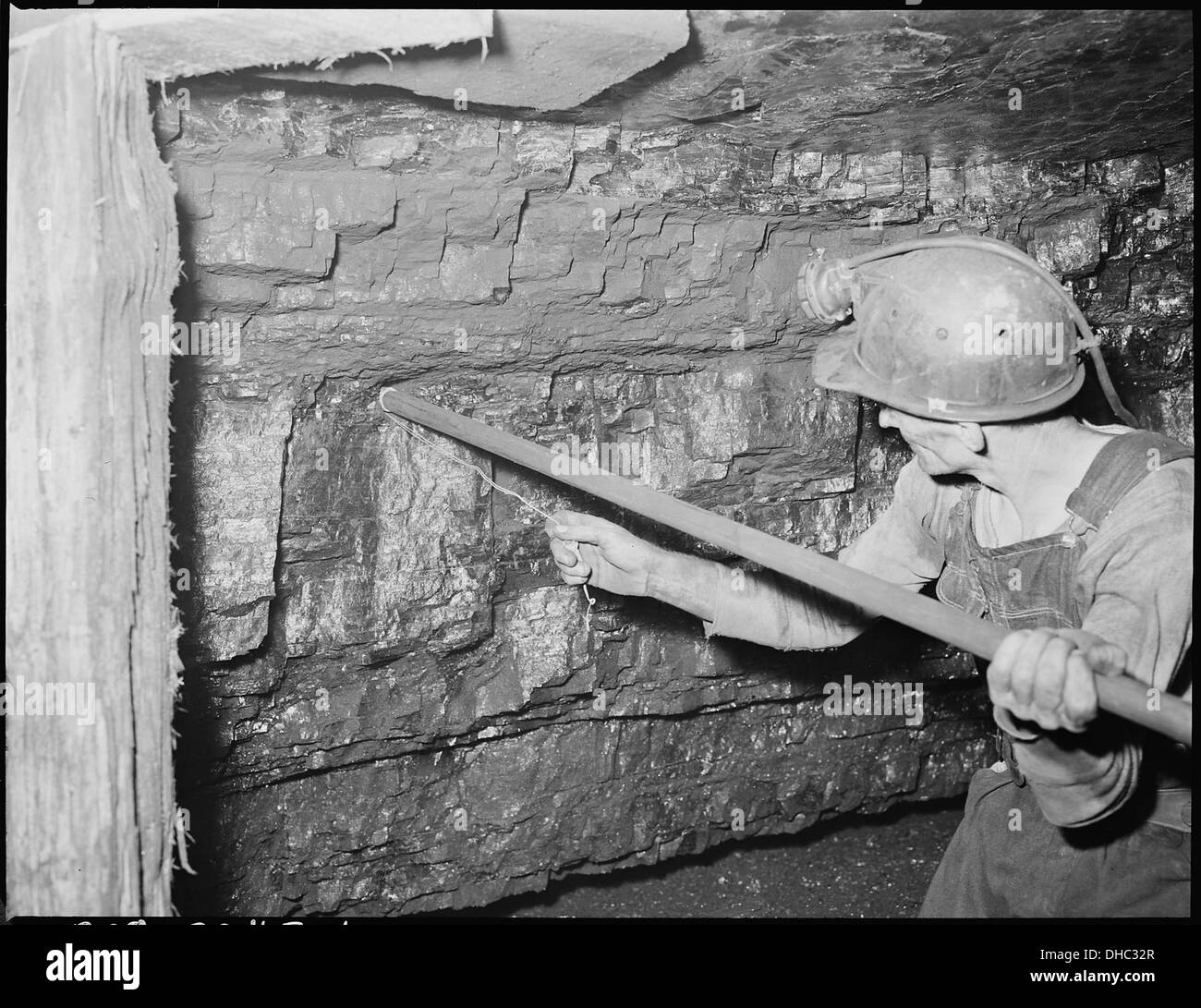 Harry Fain, una pala per carbone della Inland Steel Company, è visto compattare la polvere in preparazione all'accensione. L'immagine cattura una scena industriale in un sito di produzione dell'acciaio. Foto Stock
