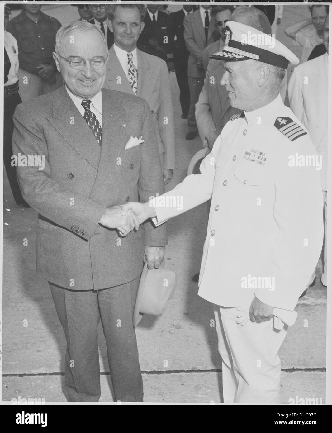 Questa fotografia mostra il presidente Harry S. Truman che stringe la mano al capitano Cecil C. Adell, comandante della base navale statunitense a Key West, Florida. L'immagine cattura un momento di interazione militare e presidenziale durante l'amministrazione di Truman. Foto Stock