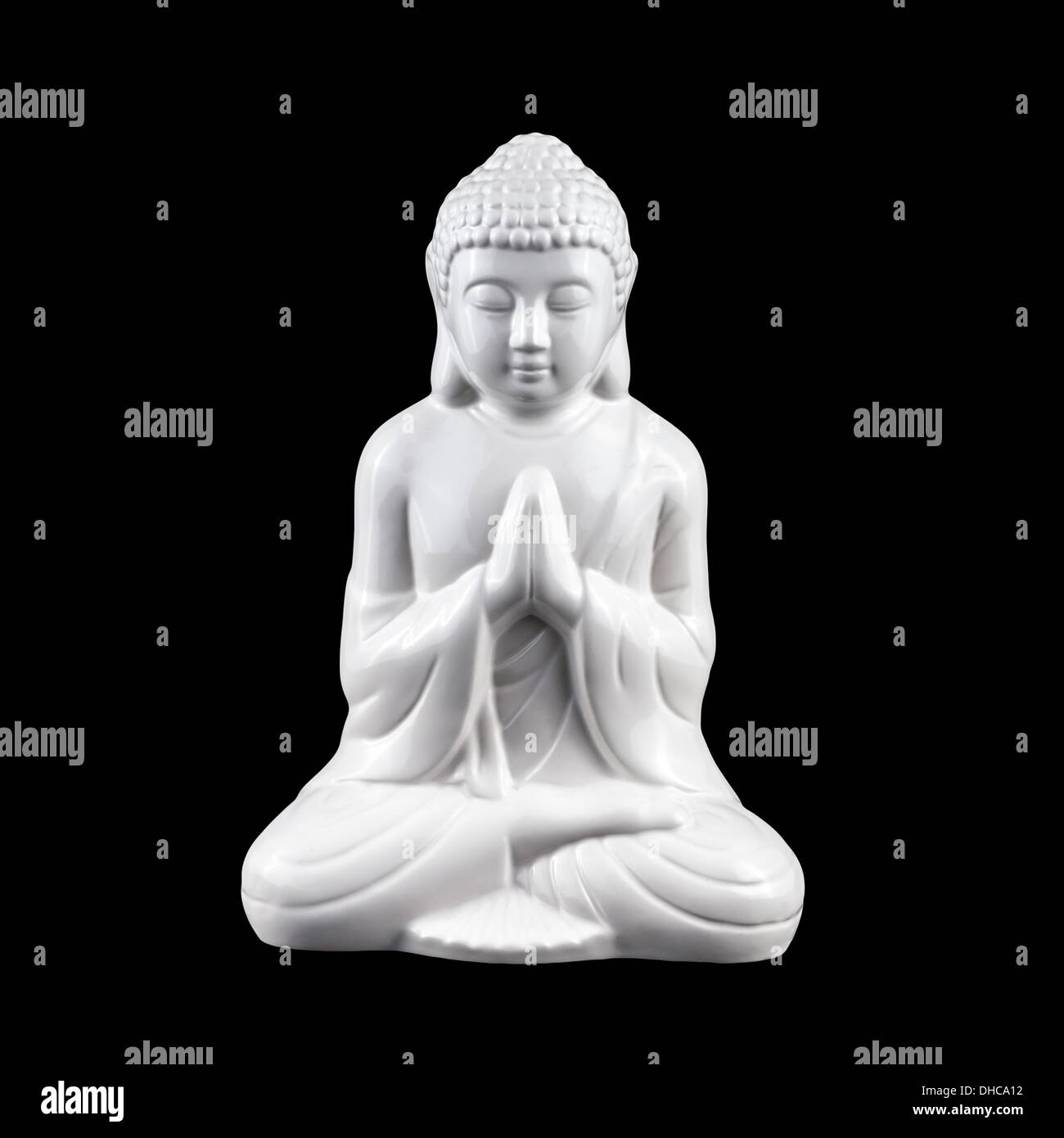 Bianco, statuetta di porcellana di stare seduti in meditazione Buddha isolato su nero Foto Stock