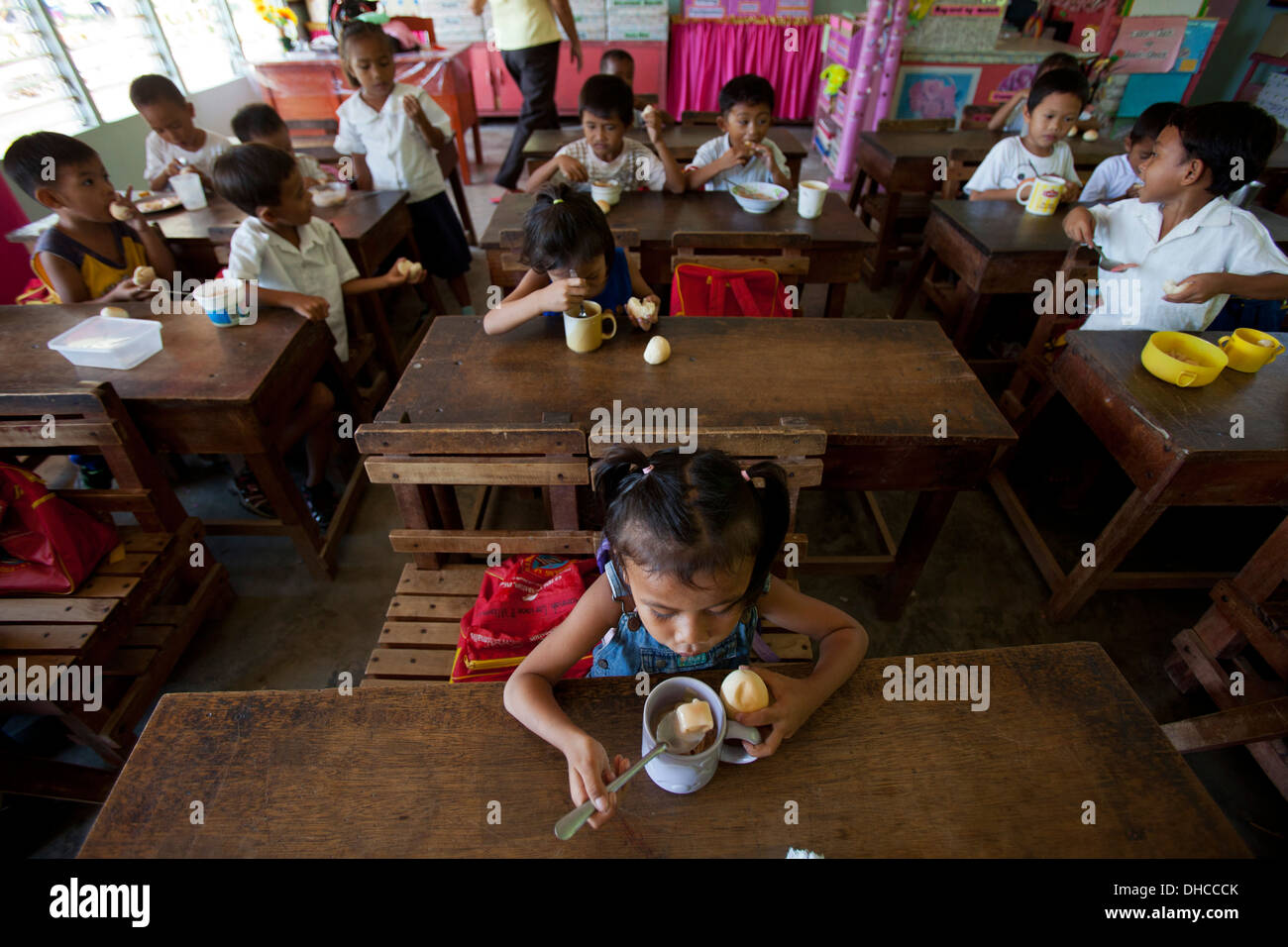 I bambini godono di un pranzo gratuito durante un programma di alimentazione evento Wasig presso la scuola elementare nel Wasig, Oriental Mindoro, Filippine Foto Stock
