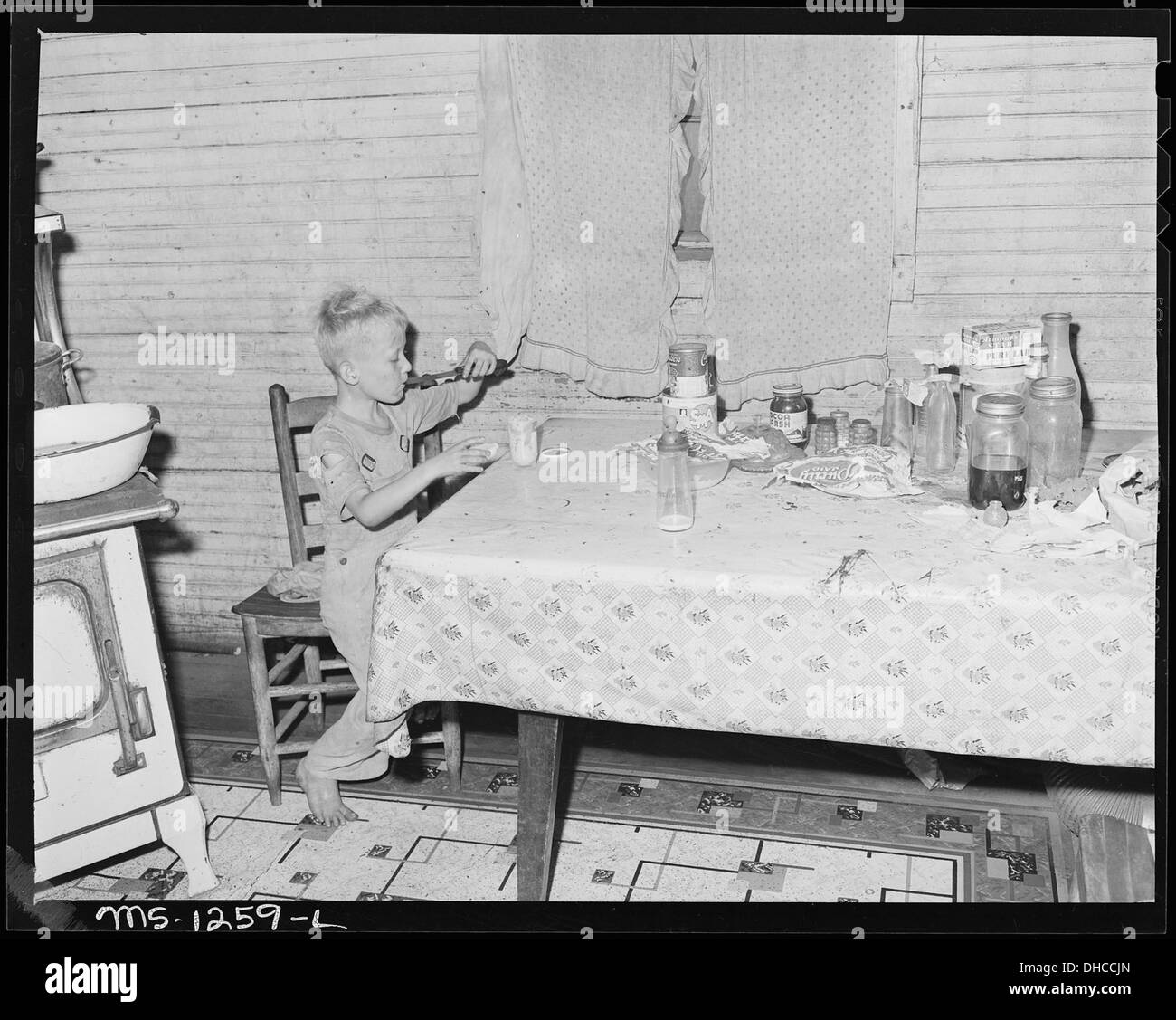 Un bambino di otto anni nella cucina della sua casa di tre stanze in una comunità mineraria, dove la sua famiglia affitta 7 dollari al mese, raffigurando le condizioni di vita delle famiglie minerarie. Foto Stock