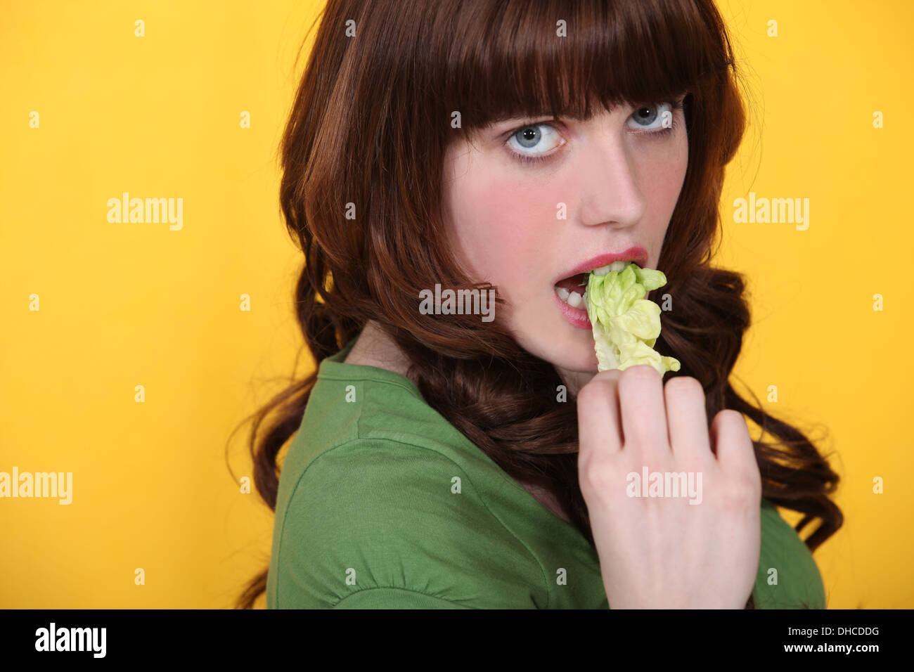 Brunette mangiare foglia di lattuga Foto Stock