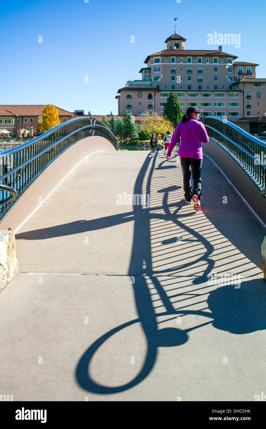 I turisti attraversare un ponte sopra il lago di Cheyenne, Broadmoor, storico e lussuoso hotel e resort, Colorado Springs, Colorado, STATI UNITI D'AMERICA Foto Stock