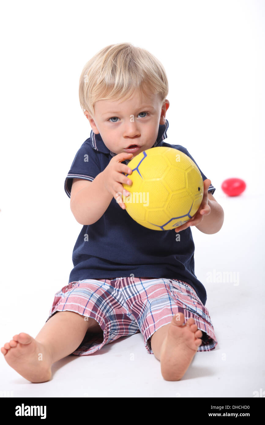 Little Boy tenendo il calcio Foto Stock