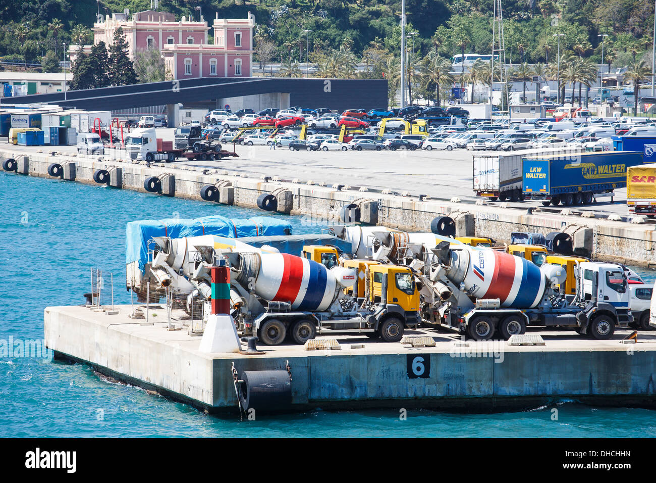 Molte colorate di calcestruzzo carrelli di miscelazione su un molo di cemento nel porto di Barcellona Foto Stock
