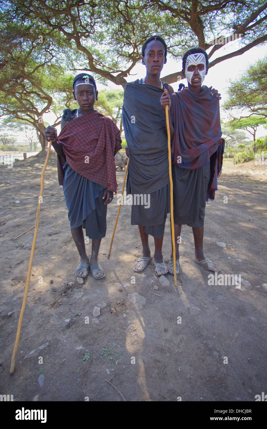 Giovani uomini Masai, non ancora guerrieri in faccia tradizionale vernice. Area del Serengeti. Tanzania, Africa. Foto Stock
