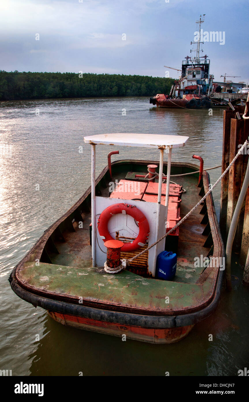Piccola barca o rimorchiatore legato fino al bacino di carenaggio non durante il funzionamento Foto Stock