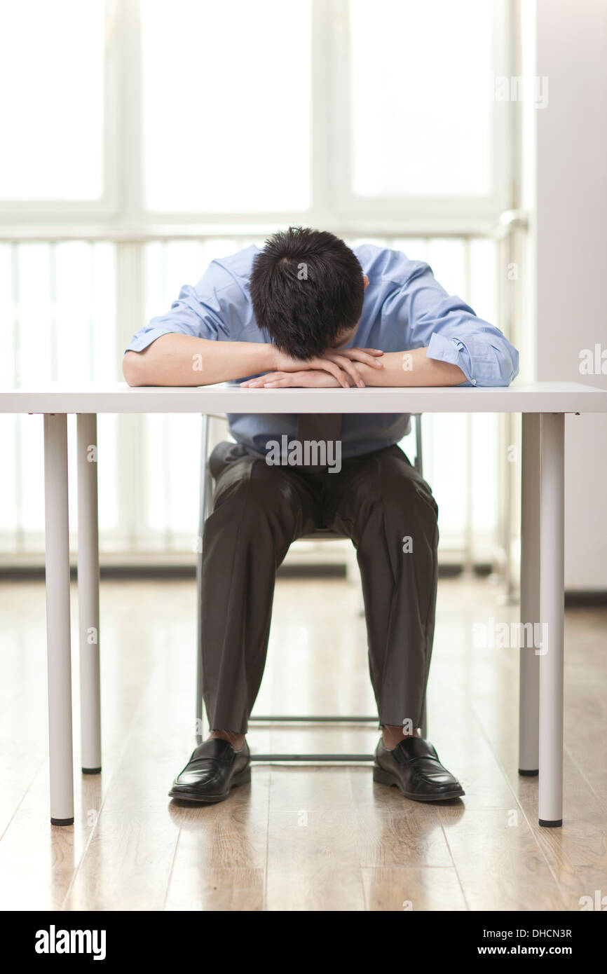Ritratto di giovane imprenditore dormire in ufficio Foto Stock