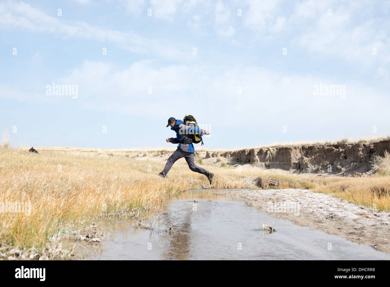 Gli escursionisti saltando su una insenatura. Giovani asiatici Foto Stock