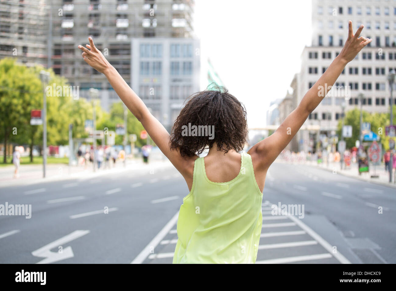 Germania, Berlino, giovani donne in città, facendo segno di vittoria, vista posteriore Foto Stock