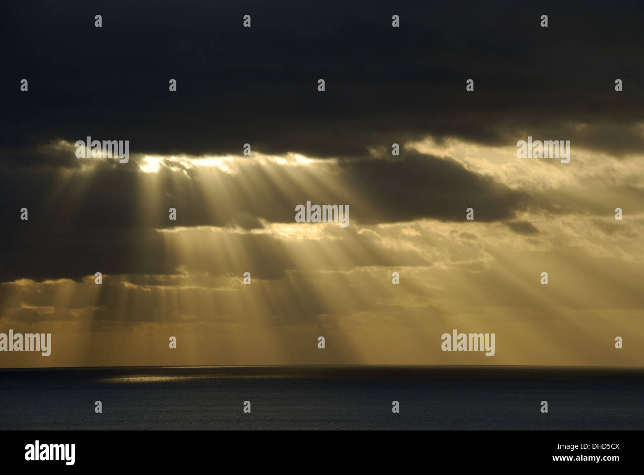 Sole splende attraverso le nuvole scure Foto Stock