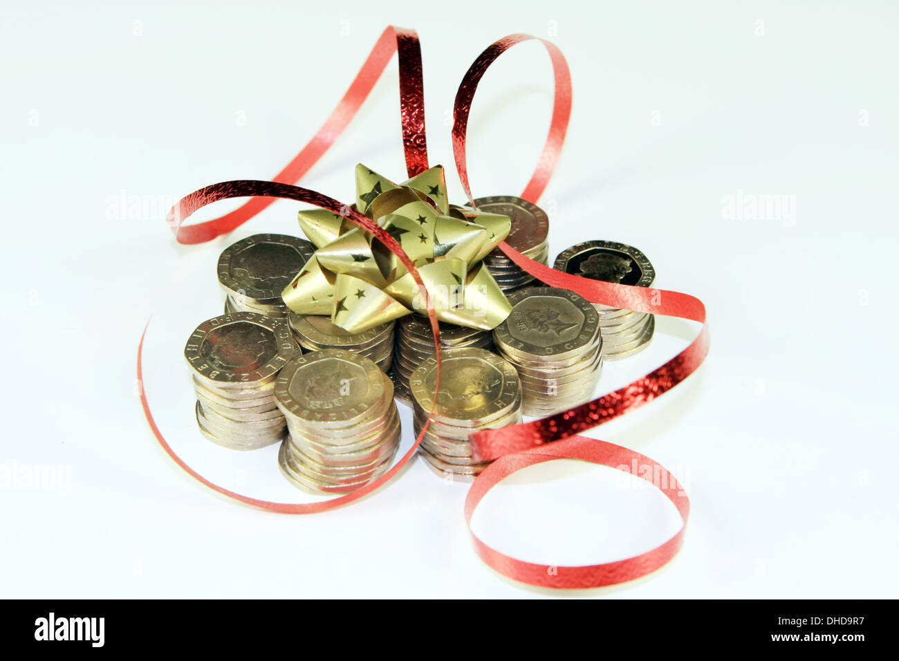 Pile di sterling 20p pezzi con fiocco decorativo e il nastro di inchiostro Foto Stock