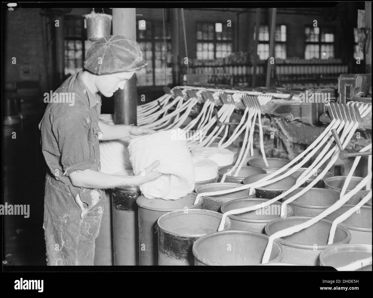 Un disegno di un lavoratore semi-qualificato che opera macchinari al Pickett Yarn Mill di High Point, Carolina del Nord, raffigurante il processo di produzione tessile a metà del XX secolo. Foto Stock