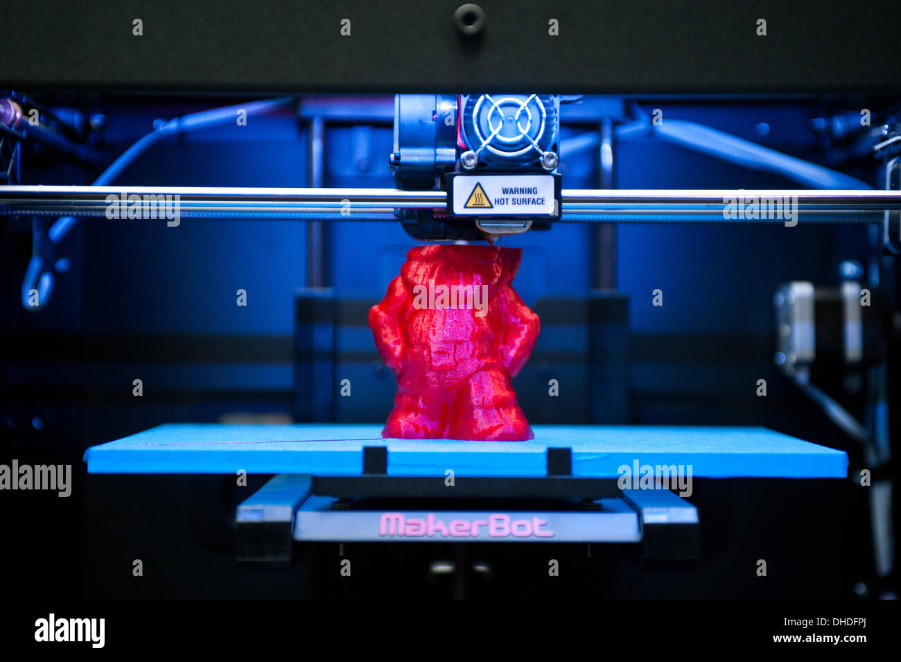Londra, Regno Unito. Il 7 novembre 2013. Un MakerBot Replicator 2 stampante 3D la stampa di un colore rosso è gnome sul display in 3D Printshow al Business Design Centre di Londra. La mostra riunisce i più grandi nomi in 3D della tecnologia di stampa a fianco dei più creativi, entusiasmanti e innovativi di individui che utilizzano processi additivi oggi. Credito: Piero Cruciatti/Alamy Live News Foto Stock