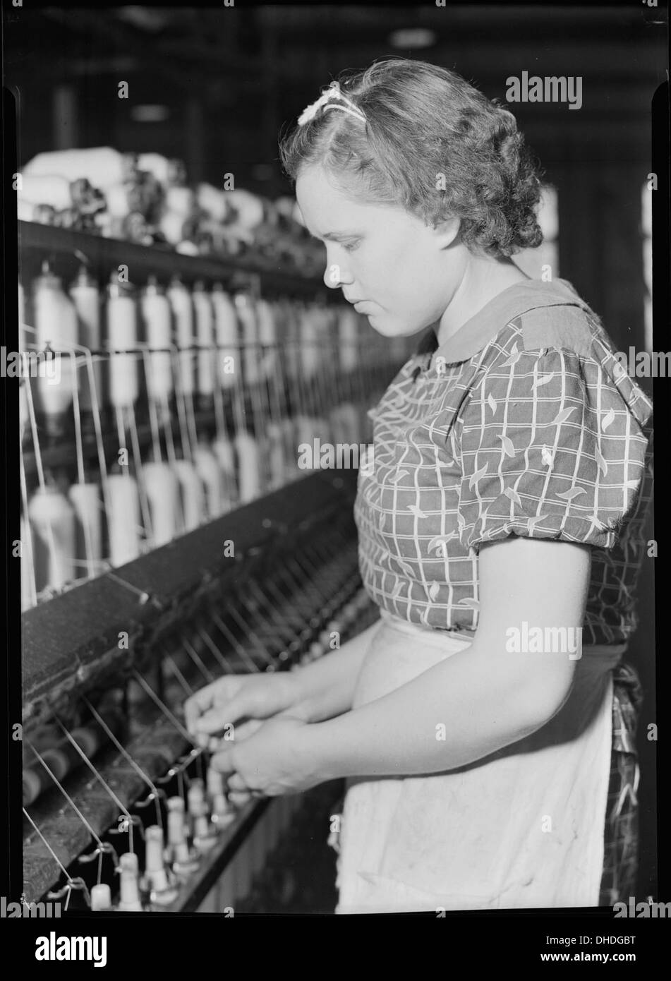 Un'abile filatrice lavora al Pickett Yarn Mill di High Point, North Carolina, dove la padronanza del mestiere richiedeva da 3 a 4 anni di formazione, dimostrando l'esperienza richiesta nella produzione tessile. Foto Stock