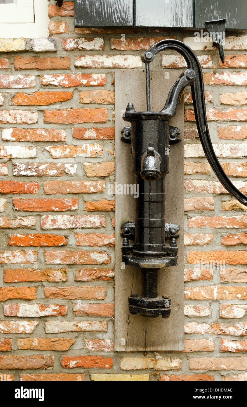 Il vecchio lato pompa acqua in un muro di mattoni Foto Stock