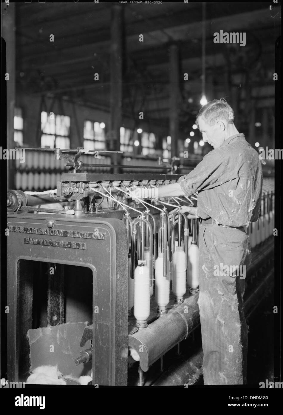 Un lavoratore altamente qualificato gestisce una macchina presso il Pickett Yarn Mill di High Point, North Carolina. Il mulino fa parte dell'industria tessile in questa regione storicamente significativa per la produzione americana. Foto Stock