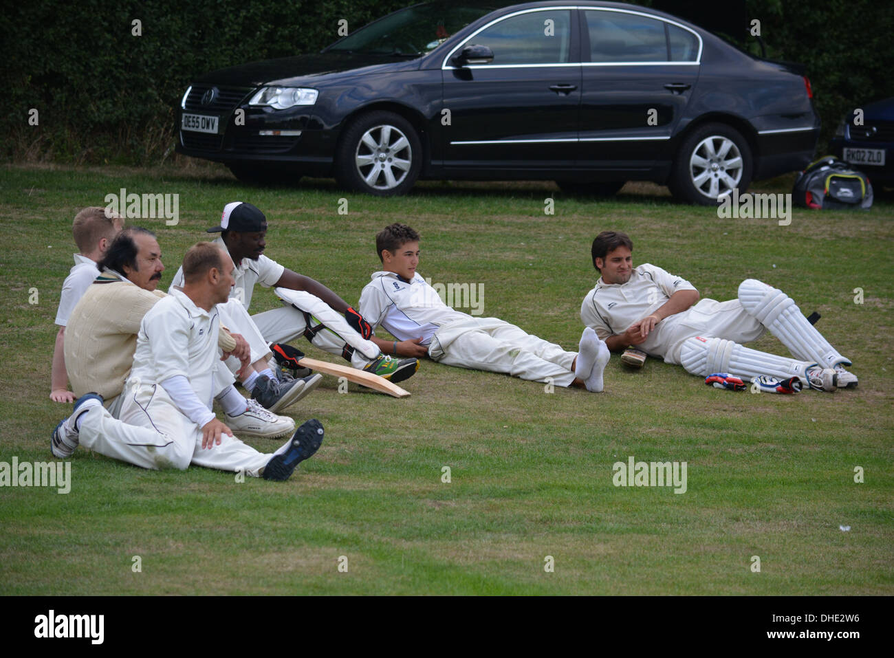 Il team di cricket seduto accanto al campo Foto Stock