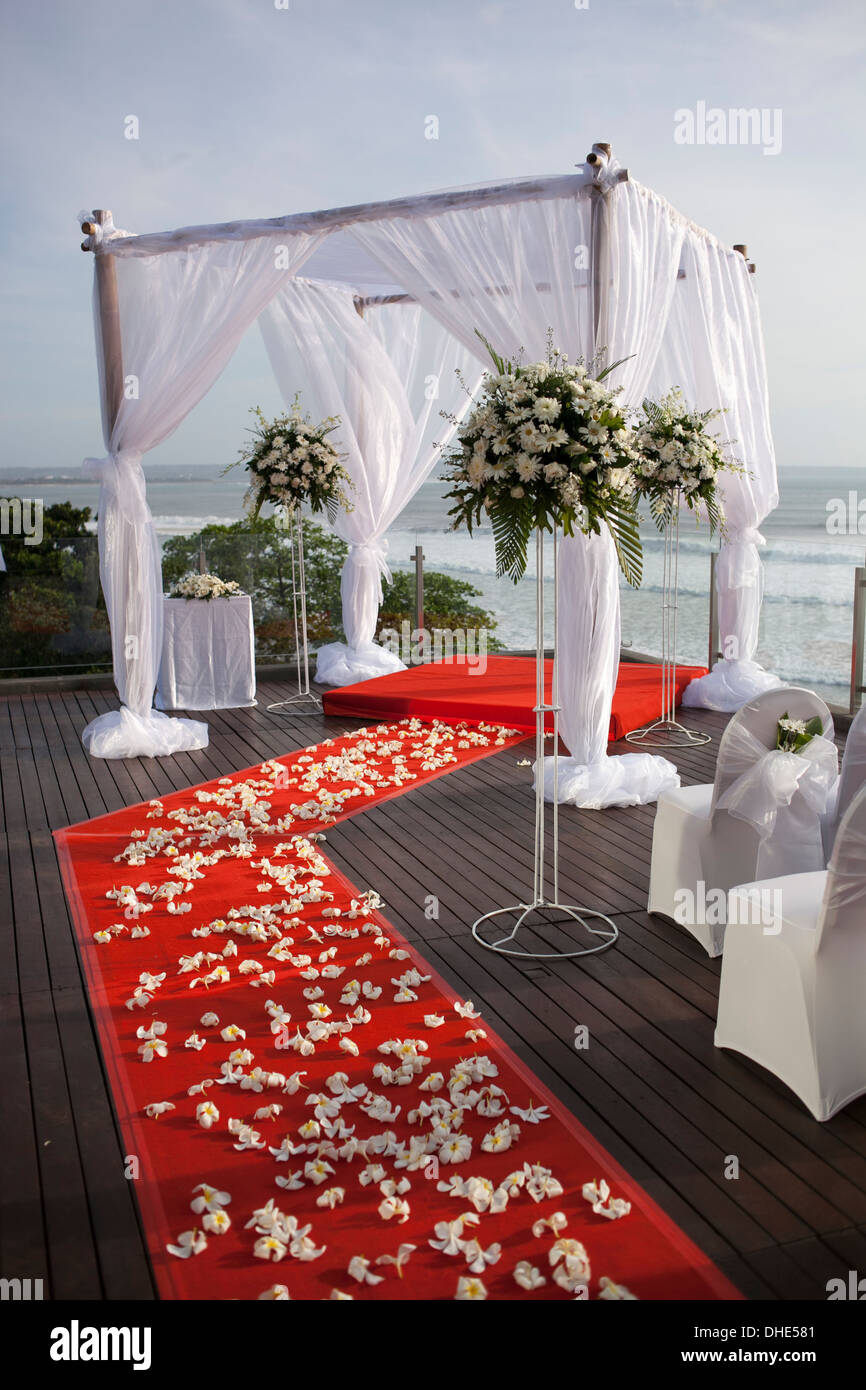 I matrimoni corridoio setup fiori rossi arredamento decorativo decorazione tramonto panno bianco struttura quadrata TAPPETINO cerimonia Foto Stock