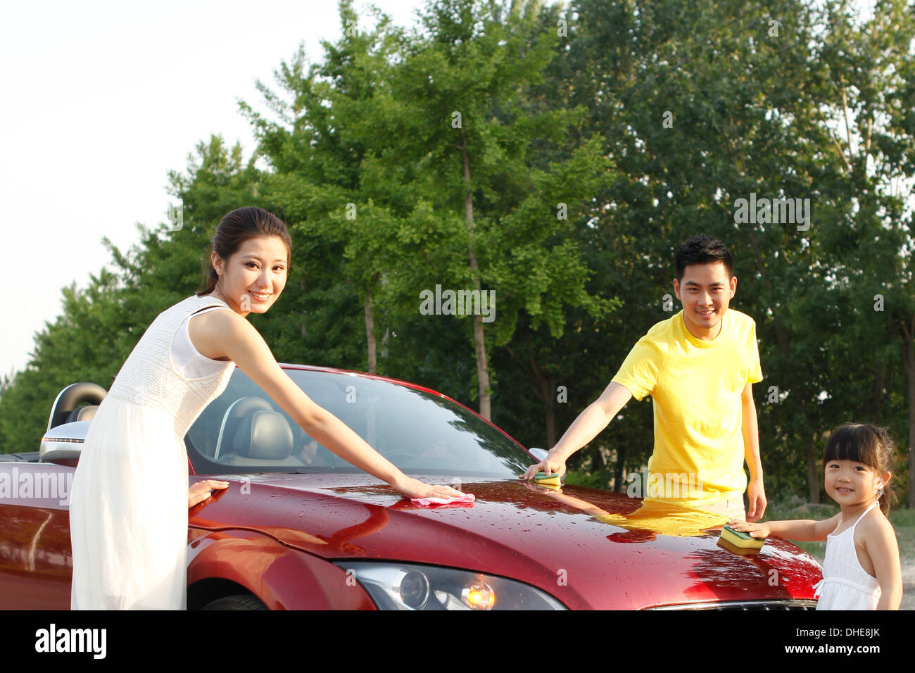 Una famiglia felice di tre guidando vetture convertibili Foto Stock