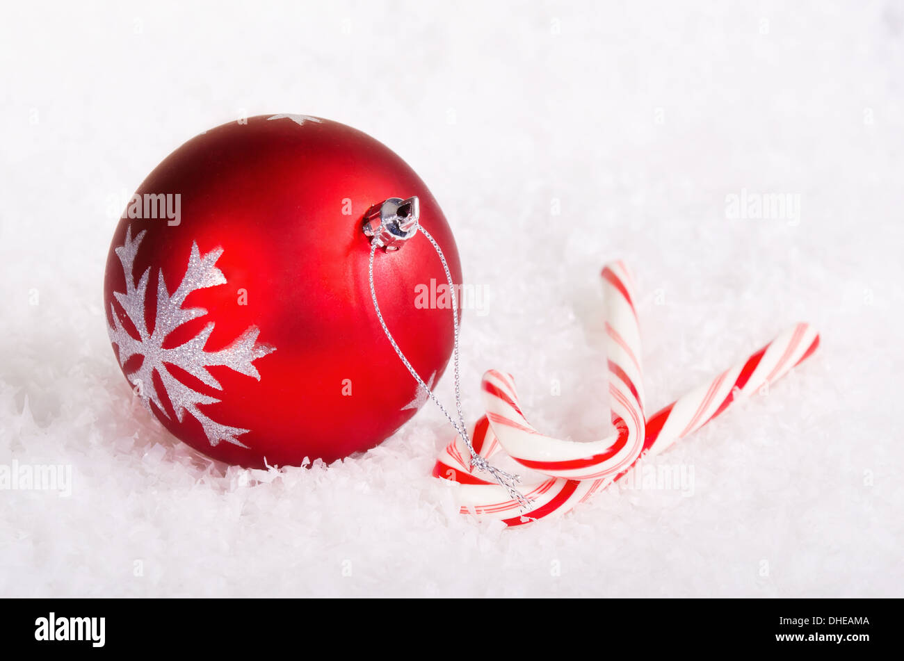 Candy canes rosso con palla di Natale ornamento sulla neve sullo sfondo Foto Stock