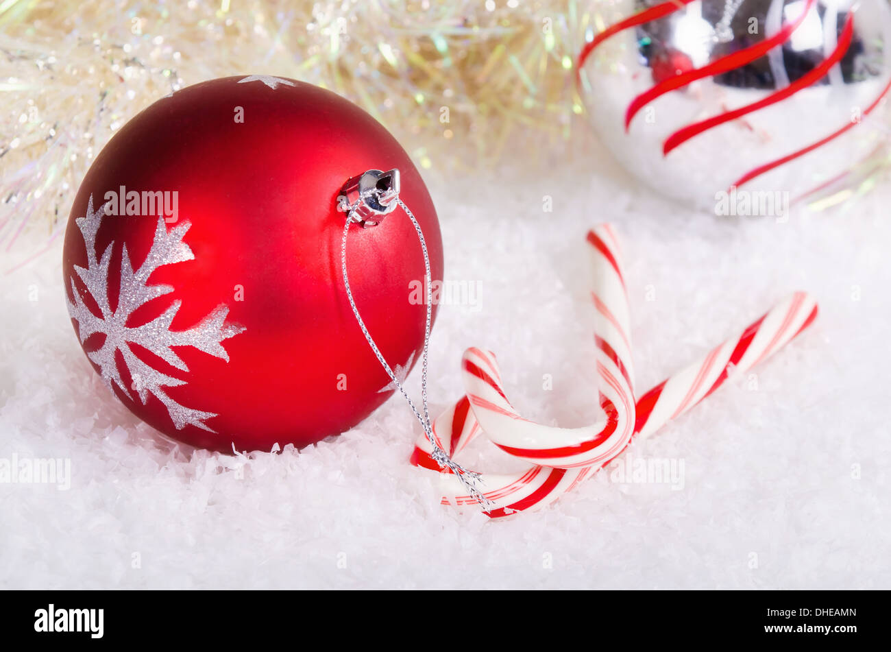 Candy canes con rosso e argento palla di Natale ornamenti sulla neve sullo sfondo Foto Stock