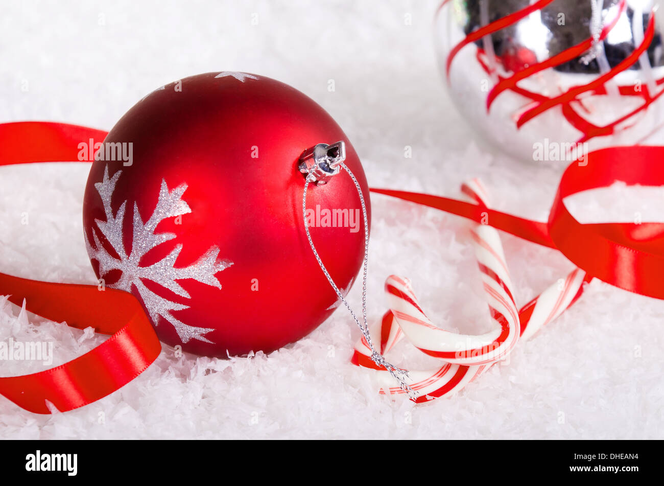 Candy canes con rosso e argento palla di Natale ornamenti sulla neve sullo sfondo Foto Stock