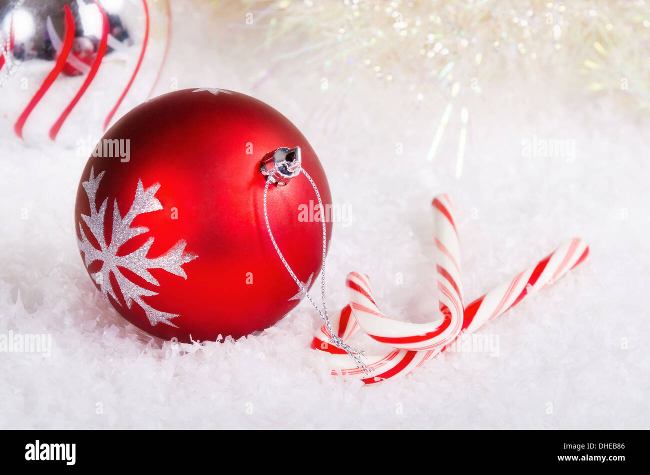 Candy canes con rosso e argento palla di Natale ornamenti sulla neve sullo sfondo Foto Stock