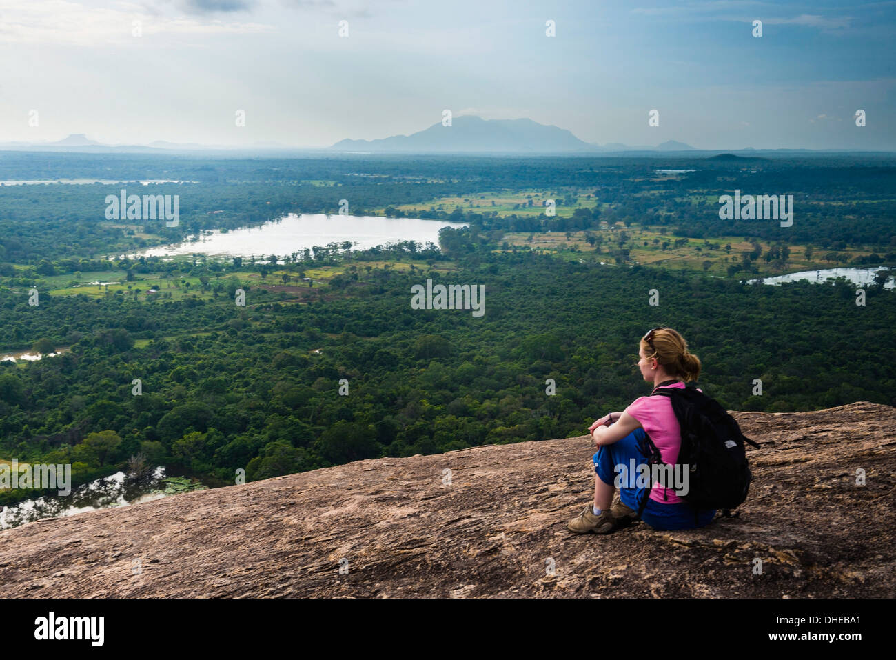 Donna seduta su roccia Pidurangala, guardando il paesaggio nella giungla del Nord provincia centrale, Sri Lanka, Asia Foto Stock