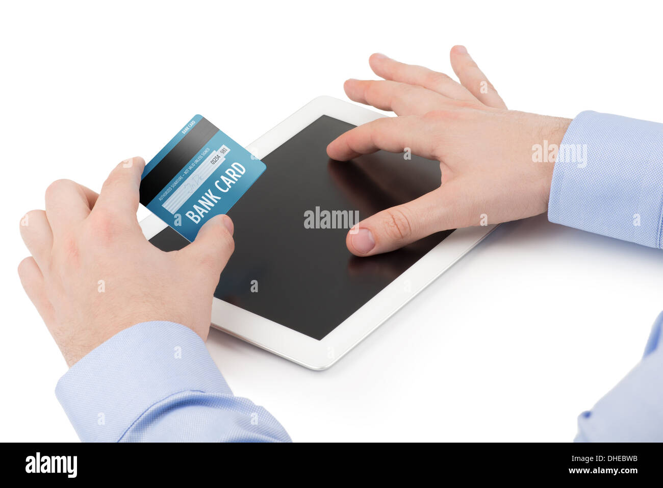 Mano d'uomo in possesso di una carta di credito su un tablet PC e l'altra che si estendono dita sullo schermo su uno sfondo bianco Foto Stock
