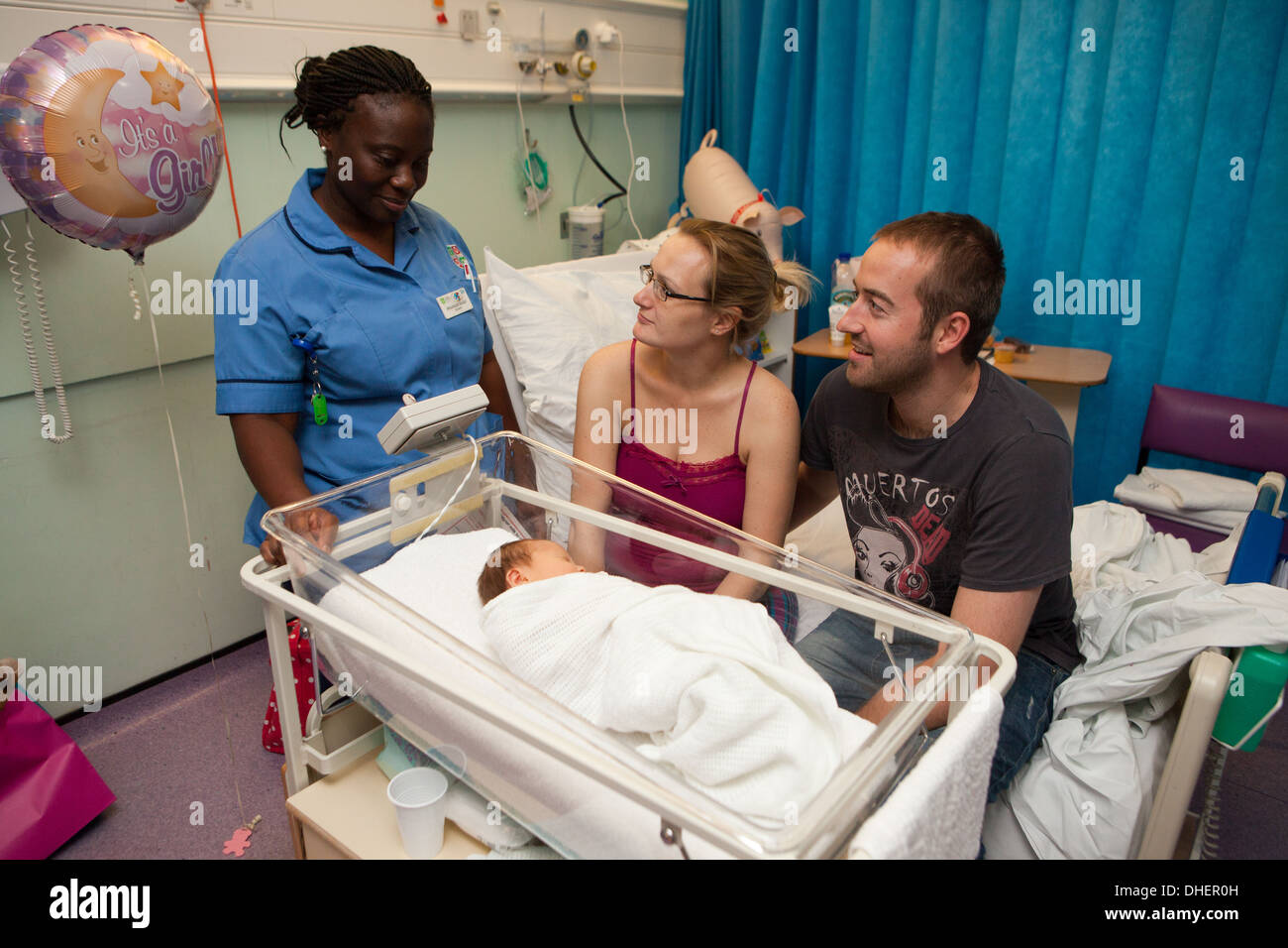 Una levatrice di colloqui con i genitori di un neonato REGNO UNITO Foto Stock