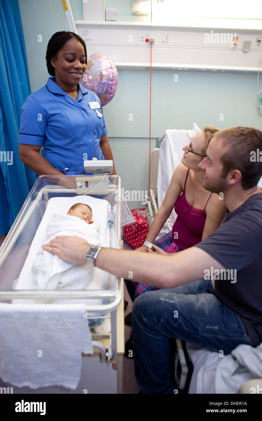 Una levatrice di colloqui con i genitori di un neonato REGNO UNITO Foto Stock