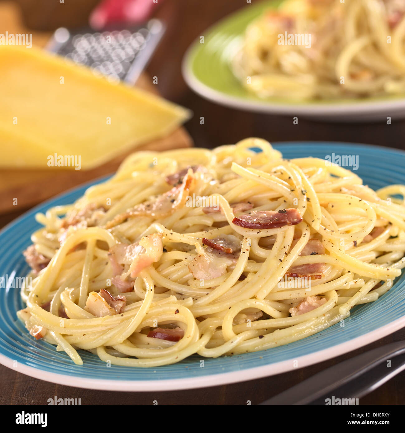 Spaghetti alla carbonara fatta con pancetta, uova, formaggio e pepe nero (fuoco selettivo, la messa a fuoco di un terzo nel pasto) Foto Stock