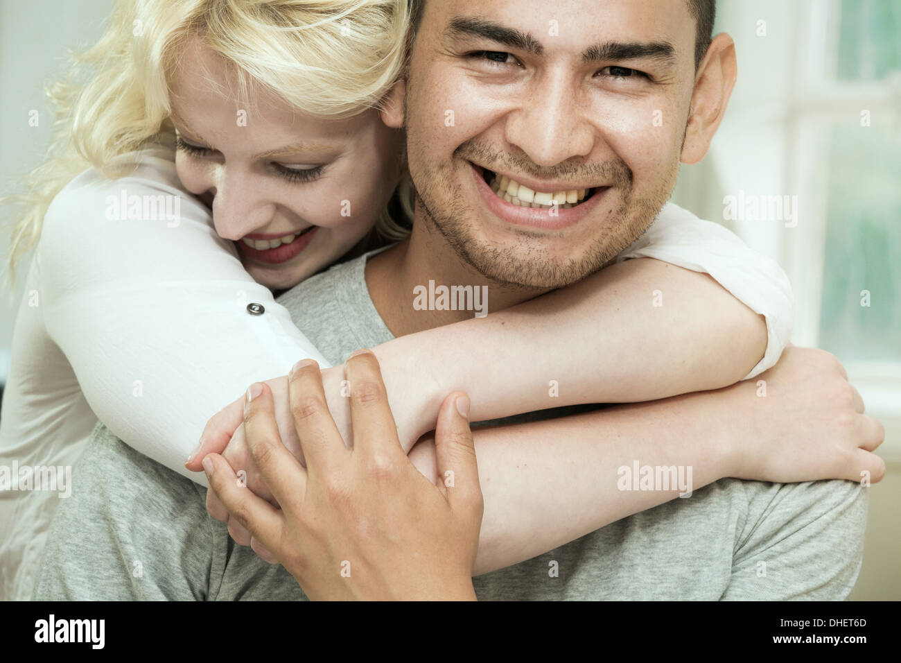 Giovane donna abbracciando il fidanzato Foto Stock