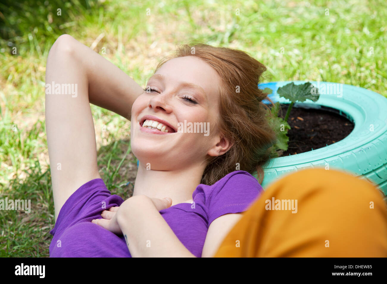 Donna sdraiata sul pneumatico Foto Stock