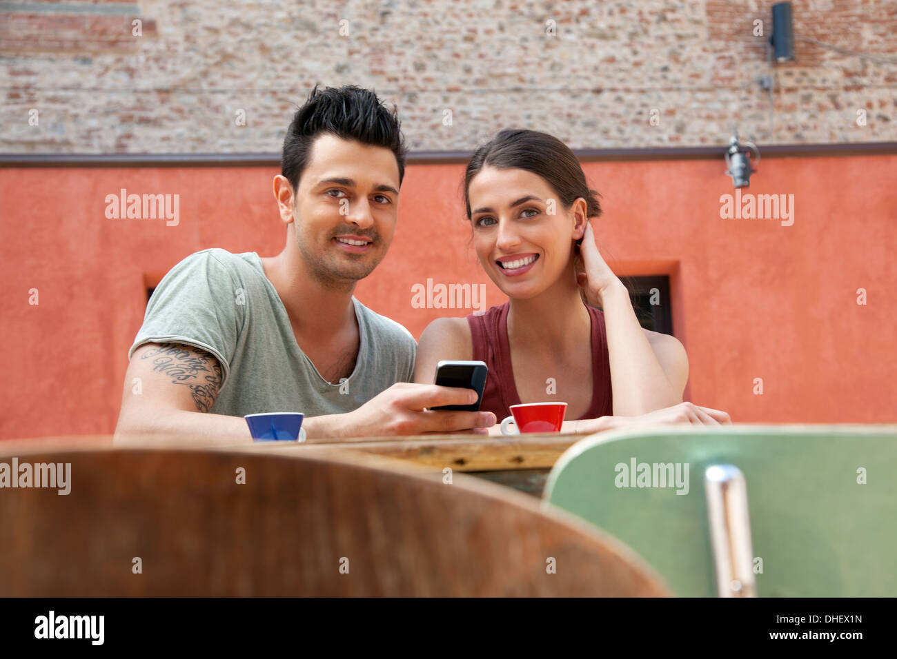 Giovane con lo smartphone al di fuori cafe, Firenze, Toscana, Italia Foto Stock