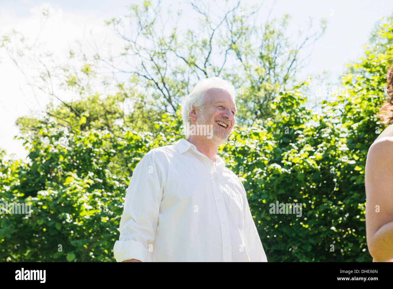 Senior uomo che indossa una camicia bianca, ridendo Foto Stock