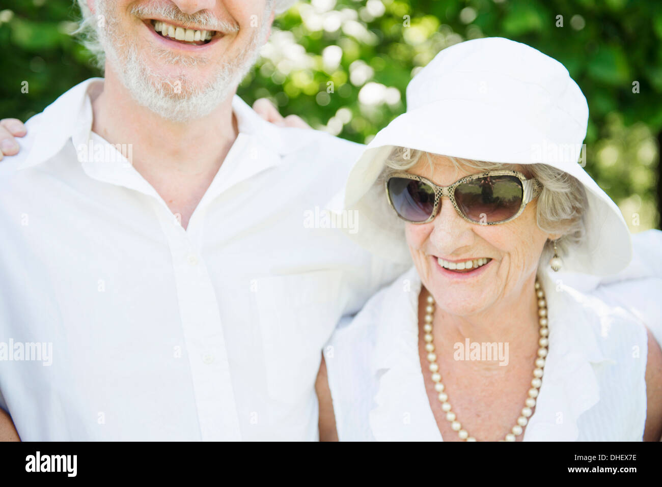Ritratto di donna senior indossando occhiali da sole e cappello bianco Foto Stock