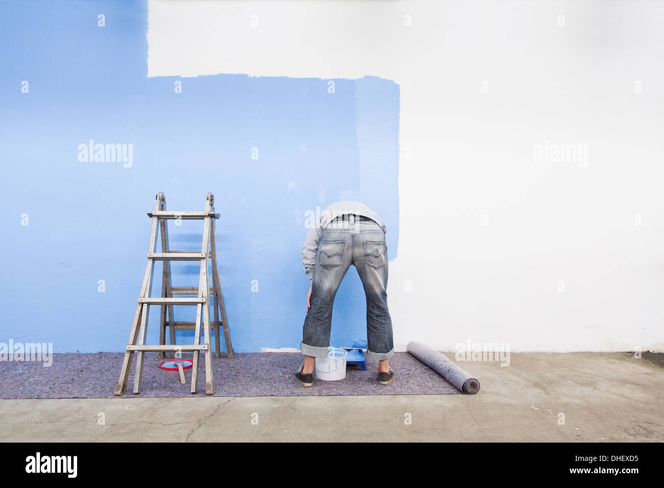 Vista posteriore dell'uomo pittura blu a parete Foto Stock