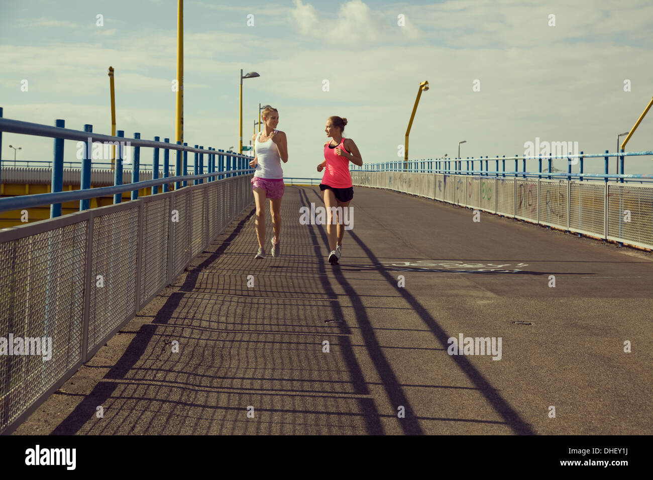 Giovani femmine per chi ama fare jogging in esecuzione sul ponte Foto Stock