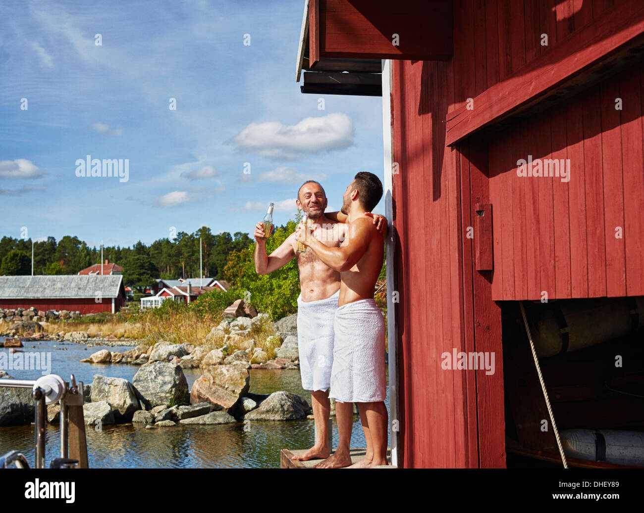 Due uomini con birre esterno sauna Foto Stock