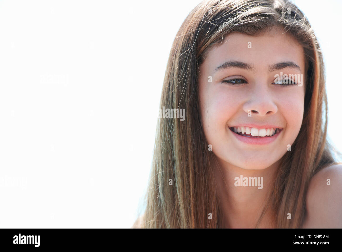 Ritratto di bruna ragazza adolescente che guarda lontano, sorridente Foto Stock